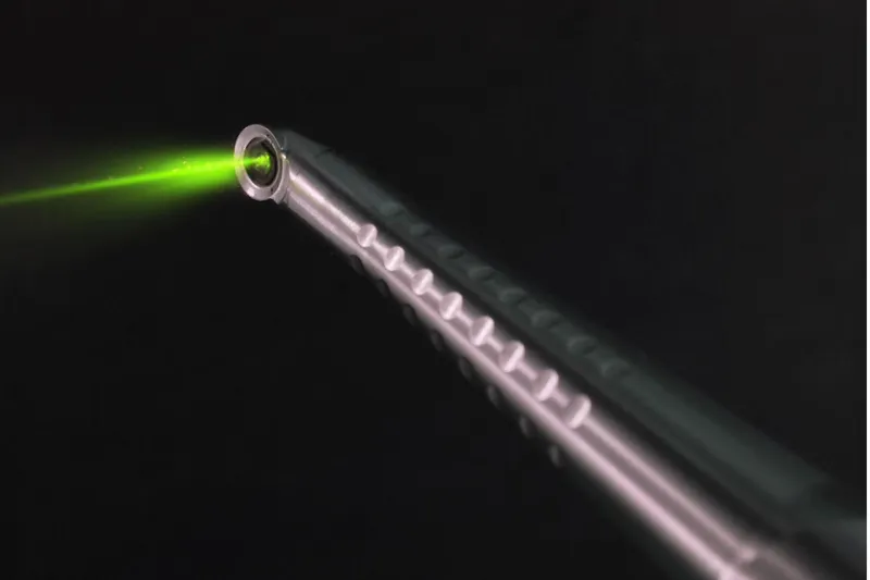 A dental laser handpiece with its green guide light