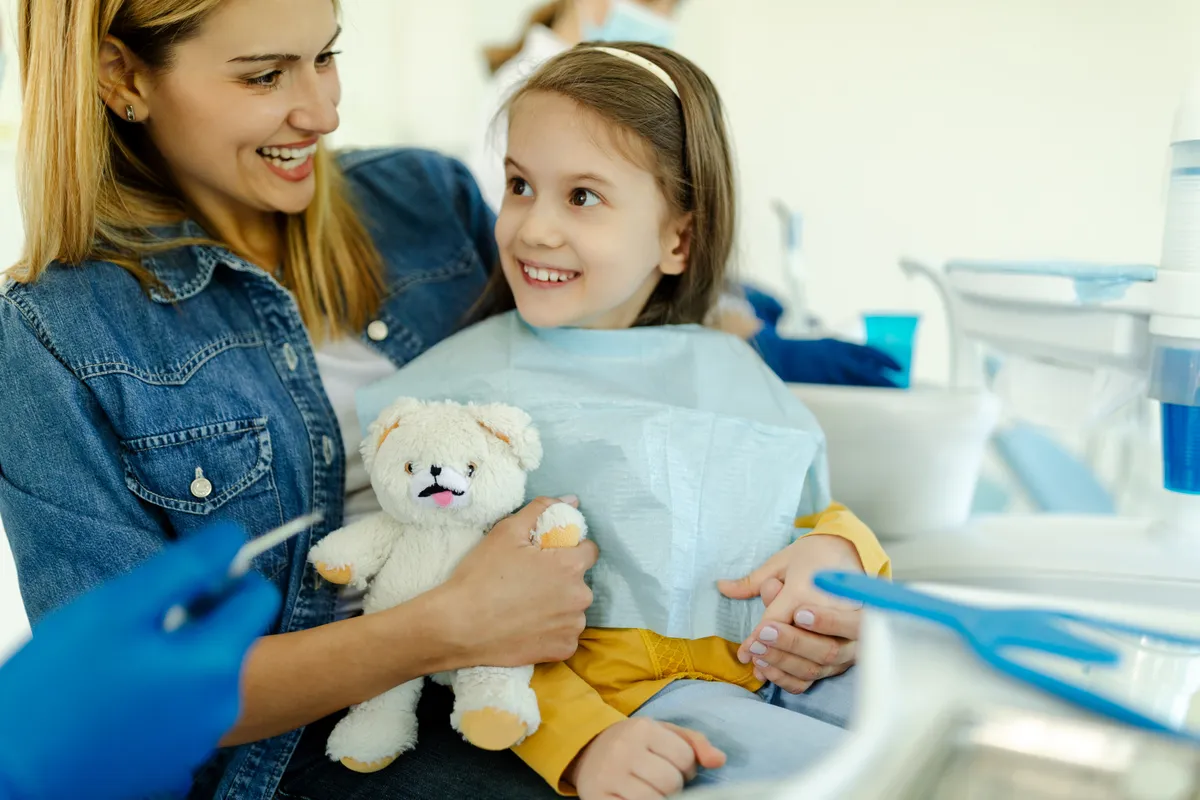 A young girl sitting comfortably in the dental chair at a Magical Smiles clinic.