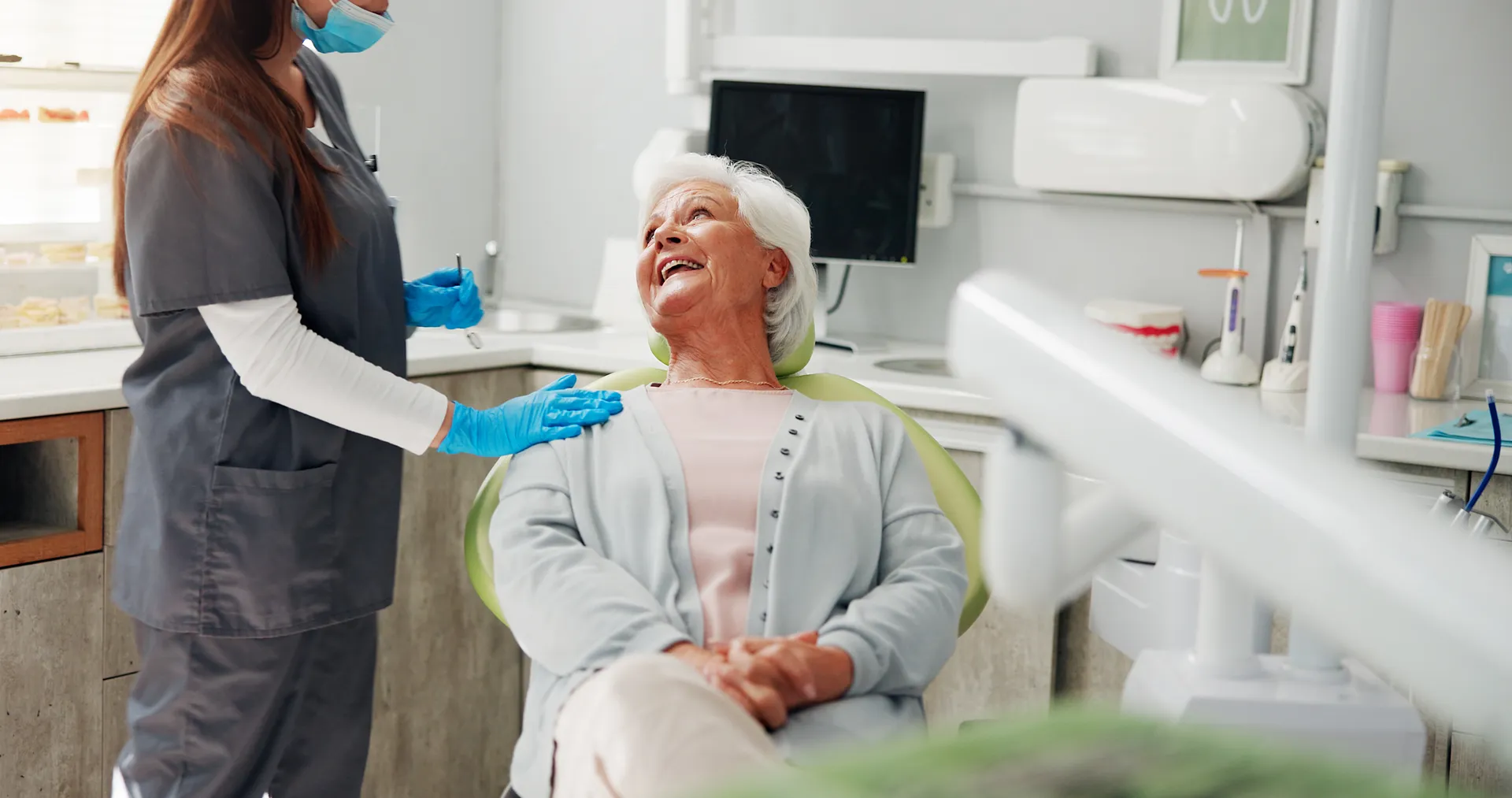 Older woman laughing with her dentist during an appointment