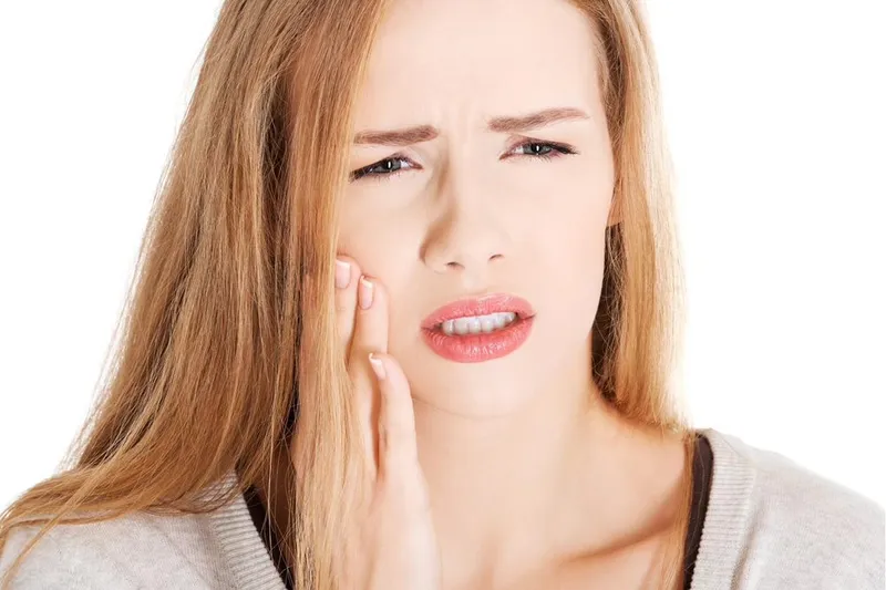 Person holding their cheek because of toothache