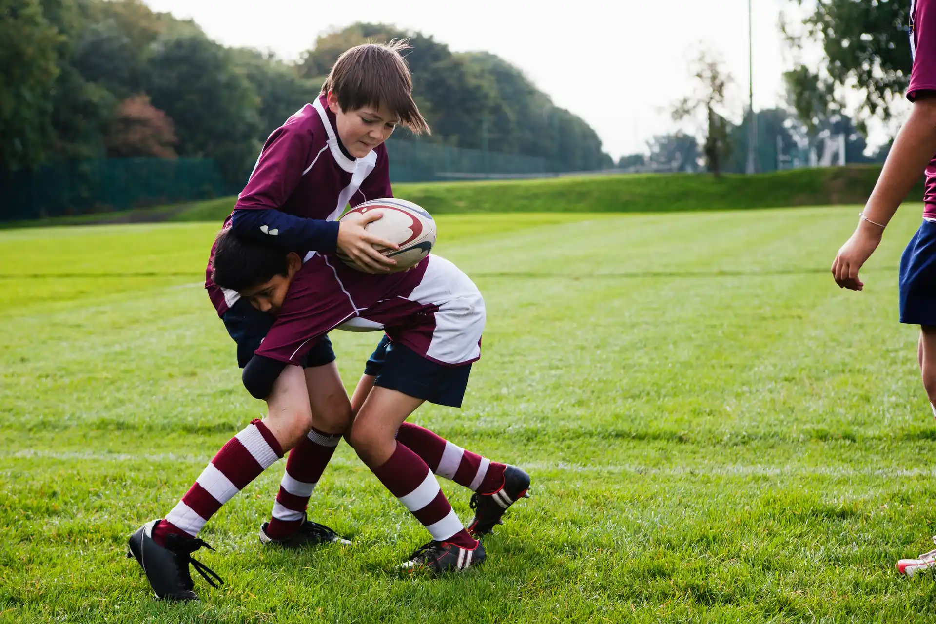 Boys playing a game of rugby on grass