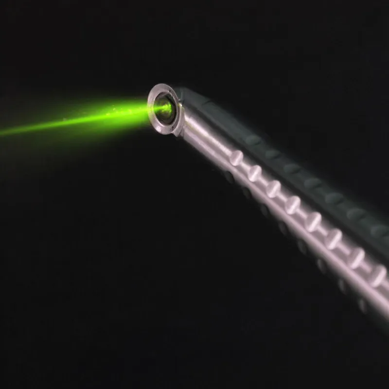 A dental laser handpiece pointing down with its guide light switched on