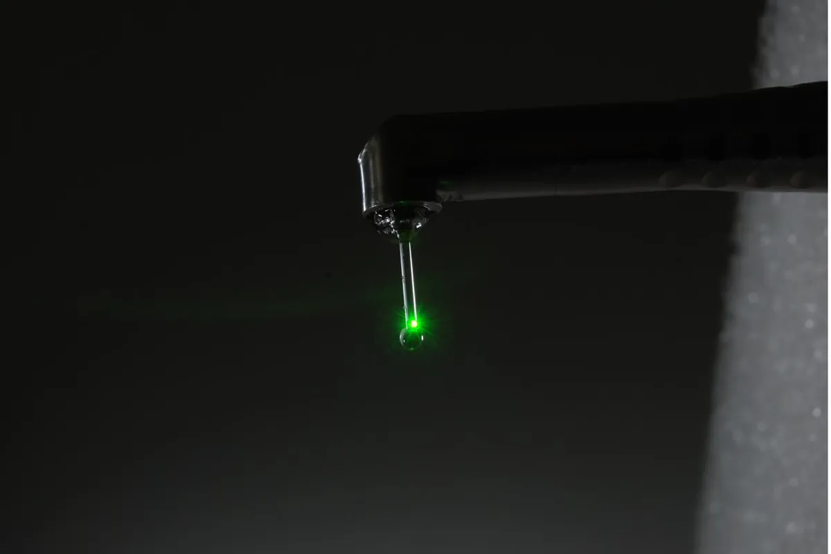 A dental laser handpiece with a green guide light